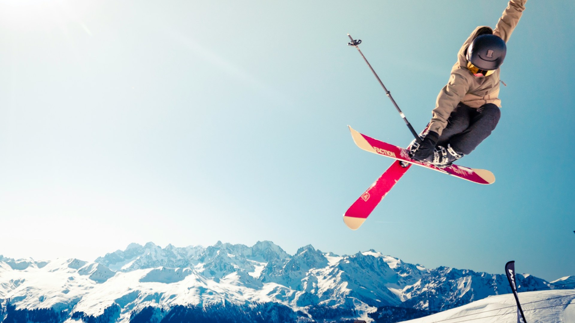 Beste skigebieden Frankrijk voor gevorderde skiërs met freestyle sprong boven besneeuwde Alpenpieken